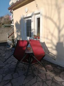 a red chair and a table in front of a building at Apartments Željka-Dobrota in Kotor