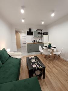 肯傑任科茲萊的住宿－Tabago Studio 15，客厅配有绿色沙发和桌子