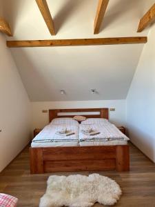 ein Bett im Dachgeschoss mit einem Teppich auf dem Boden in der Unterkunft Na Zvonici in Paseky nad Jizerou