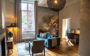 a living room with a blue couch and a table at Kasteel Wolfrath in Born