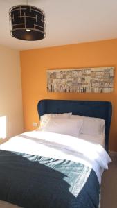 ein Schlafzimmer mit einem großen Bett und einer orangefarbenen Wand in der Unterkunft Tropical Sun Homes - Beautiful spacious home in a serene environment with free parking in Manchester