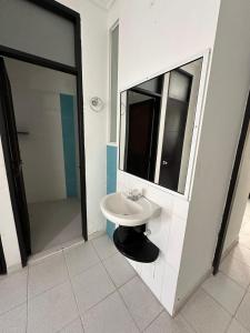 uma casa de banho com um lavatório e um espelho em AW Hotel Rodadero Suites em Santa Marta