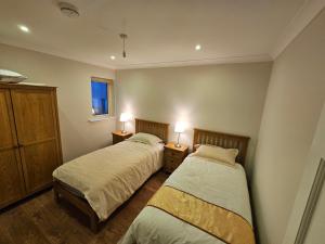 two beds in a bedroom with two lamps on tables at Central Westport Town House in Westport