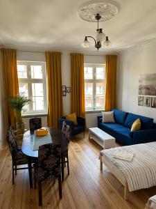 a living room with a blue couch and a table at Apartament Trzecie Piętro in Poznań