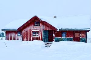 RingsakerLarge cabin with Sjusjøens best view, sauna and ski in out的一座覆盖着积雪的旧红色谷仓 更多18张照片