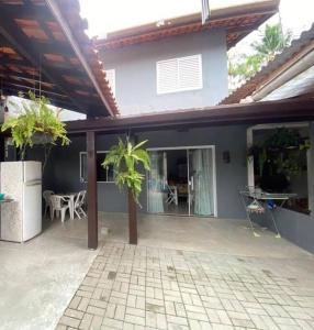a house with a patio with a palm tree in it at Casinha da Nete (6 pessoas) in São Sebastião