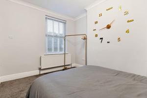 a white room with a clock on the wall at Liz's 4 Bed House: Close to the Motor Point Arena in Nottingham