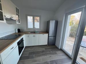 Una cocina con gabinetes blancos y un refrigerador de acero inoxidable. en maison t2 avec jaccuzi wifi parking, en Saint-Cyr-sur-Mer 4 fotos más