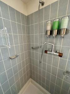a bathroom with a shower with blue tiles at Studio Serenity, 4 min walk to center! in Crans-Montana