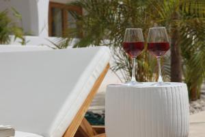 dois copos de vinho tinto sentados numa mesa em Hide and Seek Resort em Popoyo