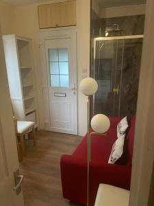 a living room with a red couch and a door at Livadia House at St Leonards on Sea in St. Leonards