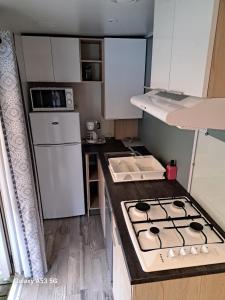 a small kitchen with a stove and a sink at RIVA BELLA MH 171 in Ouistreham