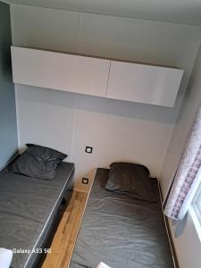 Habitación pequeña con 2 camas y ventana en RIVA BELLA MH 171, en Ouistreham