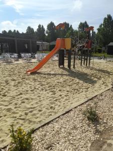 a playground with a red slide in the sand at RIVA BELLA MH 171 in Ouistreham