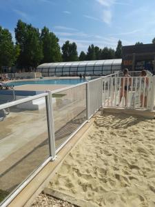 a group of people standing next to a swimming pool at RIVA BELLA MH 171 in Ouistreham