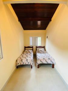 Duas camas num pequeno quarto com tecto em Casinha da Nete (6 pessoas) em São Sebastião