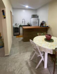 eine Küche mit einem Tisch und eine Küche mit einem Waschbecken in der Unterkunft Casinha da Nete (6 pessoas) in São Sebastião