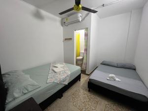 - une chambre avec 2 lits et un ventilateur de plafond dans l'établissement HOSTAL MY HOUSE, à Doradal