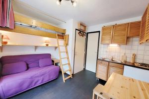 een kamer met een paarse bank en een stapelbed bij Lovely 16 m family studio with balcony in Le Monêtier-les-Bains