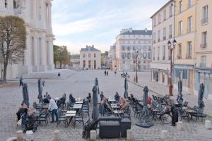 a group of people sitting at tables in a city street at L’ESPERANCE in Versailles