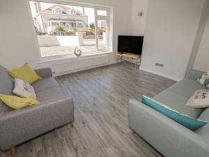 a living room with two couches and a large window at Bay View Bungalow Benllech, 5 Min Walk from Beach in Benllech