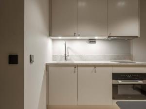 a kitchen with white cabinets and a sink at Slopeside Serenity in Are Ski-in Ski-out Studio in Åre