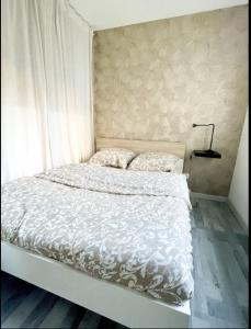 a bed with a white comforter and two pillows at Studio centre-ville Petite Venise in Colmar
