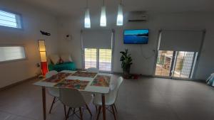 a dining room with a table and chairs and a tv at La Casa de Sole in Paraná