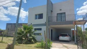 a white house with a car parked in front of it at La Casa de Sole in Paraná