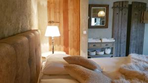 a bedroom with a couch and a lamp and a mirror at Le Lodge des Flâneurs in Vielsalm