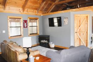ein Wohnzimmer mit einem Sofa und einer Holzdecke in der Unterkunft Hell Creek Cabin on the White River 