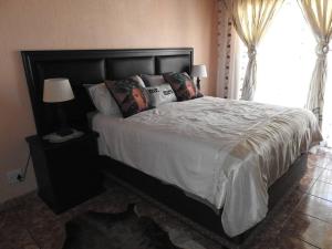 une chambre avec un grand lit avec des oreillers dessus dans l'établissement Collin's Rest, à Marloth Park 29 autres photos