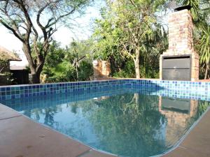 a swimming pool in a yard with trees at Collin's Rest in Marloth Park