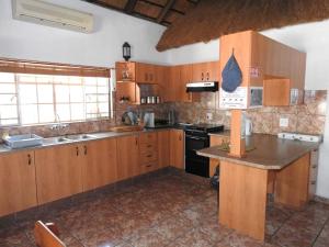 a large kitchen with wooden cabinets and a counter top at Collin's Rest in Marloth Park