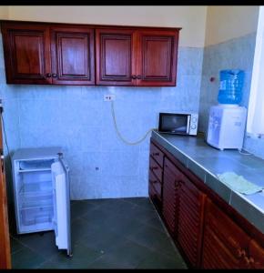 a kitchen with a counter with a microwave and a refrigerator at Chloe Isla 2 apartment Malindi in Malindi