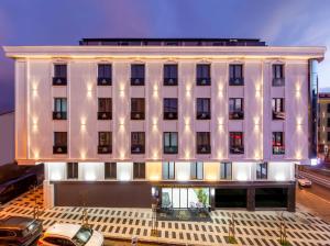 a large white building with lights on it at Premium Dem Hotel - Istanbul Airport in Arnavutköy