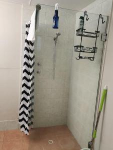 a shower with a black and white shower curtain at Country Retreat The Blue Cottage in Gingin