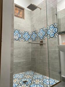 a bathroom with a shower with blue and white tiles at Finca hotel la fortuna in San Pedro