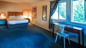 a bedroom with a bed and a desk and a window at Polar Peak Chalet by Fernie Lodging Company in Fernie