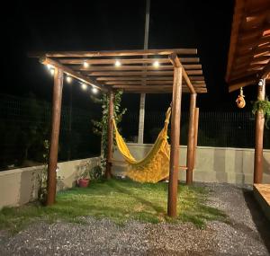 a hammock under a pergola at night at Casa Passarinho in Vale do Capao