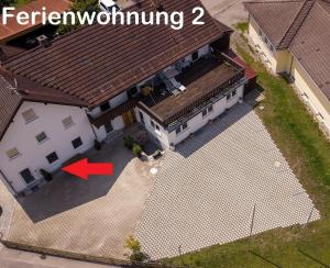 an overhead view of a large white house with a red arrow at Ferienwohnung 2 - b48936 in Lechbruck