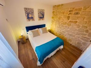 een slaapkamer met een bed en een stenen muur bij Casa Rural Claudia in Puigmoreno