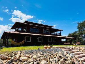 a large house with a rock pile in front of it at Casa Passarinho - Vale do Capão in Vale do Capao