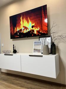 a television on a white entertainment center with a fireplace at New Charm Apartments near Border in Narva