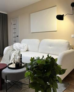 ein Wohnzimmer mit einem weißen Sofa und einem Tisch in der Unterkunft New Charm Apartments near Border in Narva