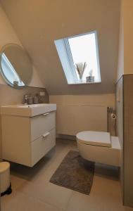 une salle de bain avec toilettes, lavabo et fenêtre dans l'établissement Ferienwohnung am Okertal, à Goslar