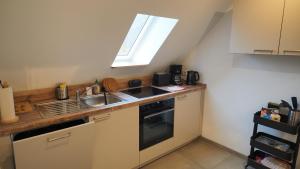 une petite cuisine avec un évier et une fenêtre dans l'établissement Ferienwohnung am Okertal, à Goslar