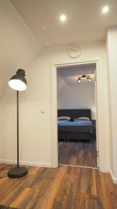 - une chambre avec un lit et une lampe sur du parquet dans l'établissement Ferienwohnung am Okertal, à Goslar 12 autres photos