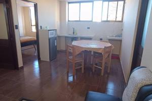 eine Küche mit einem Tisch und einigen Stühlen sowie einem Tisch und einer Küche in der Unterkunft nuevo y hermoso departamento (9) in Sucre
