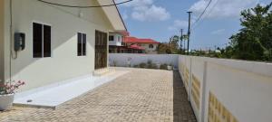 a balcony of a white house with a brick sidewalk at Kapowlito Real Estate Casa #1 Mon Plaisirweg in Paramaribo